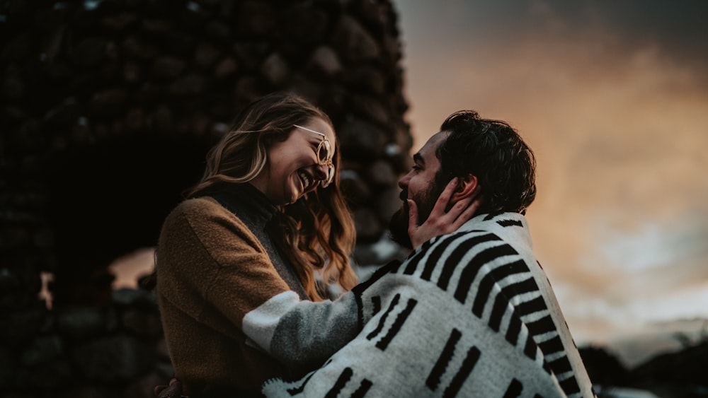 a man holding a woman wrapped in a blanket