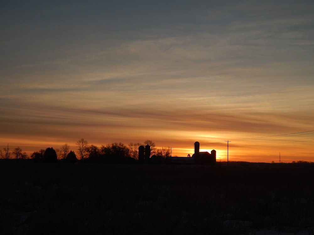 Le soleil se couche sur une ferme avec des silos