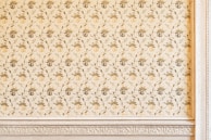 A wall covered with elegant wallpaper featuring subtle floral patterns that complement a vintage photo frame.
