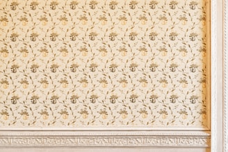 Detail of decorative stencil work on a bedroom wall in soft pastel colors