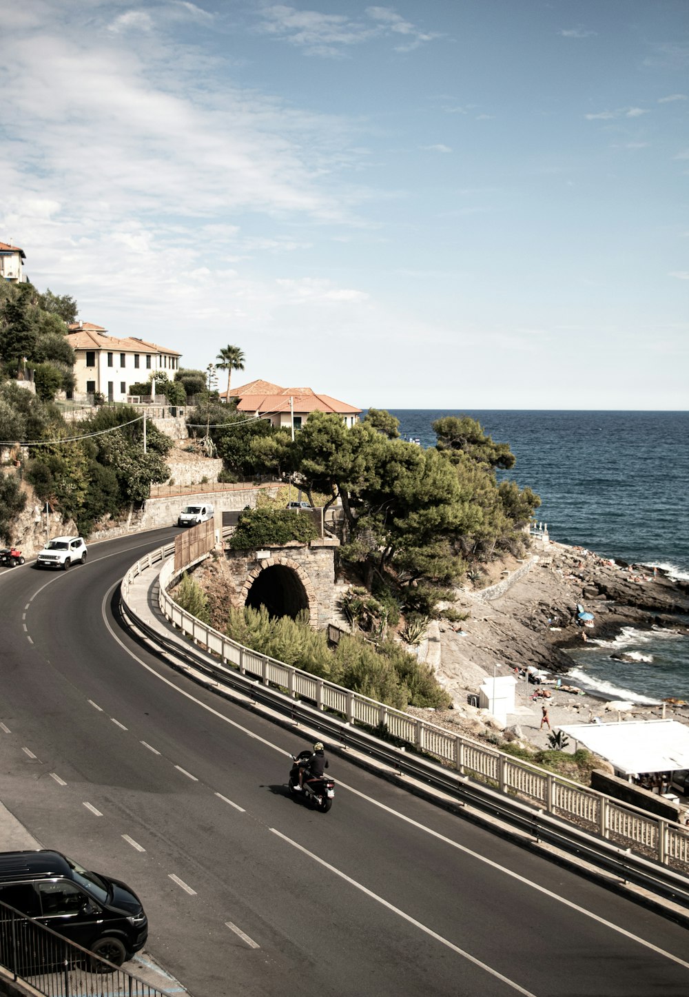 a car driving down a road next to the ocean