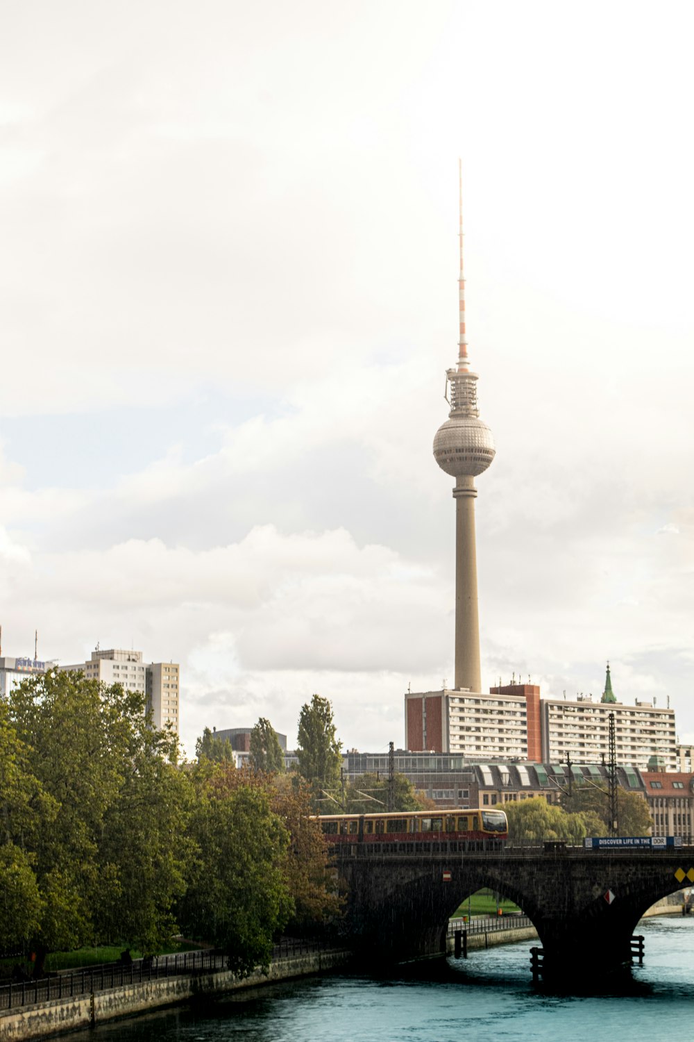 a river with a bridge and a tower in the background