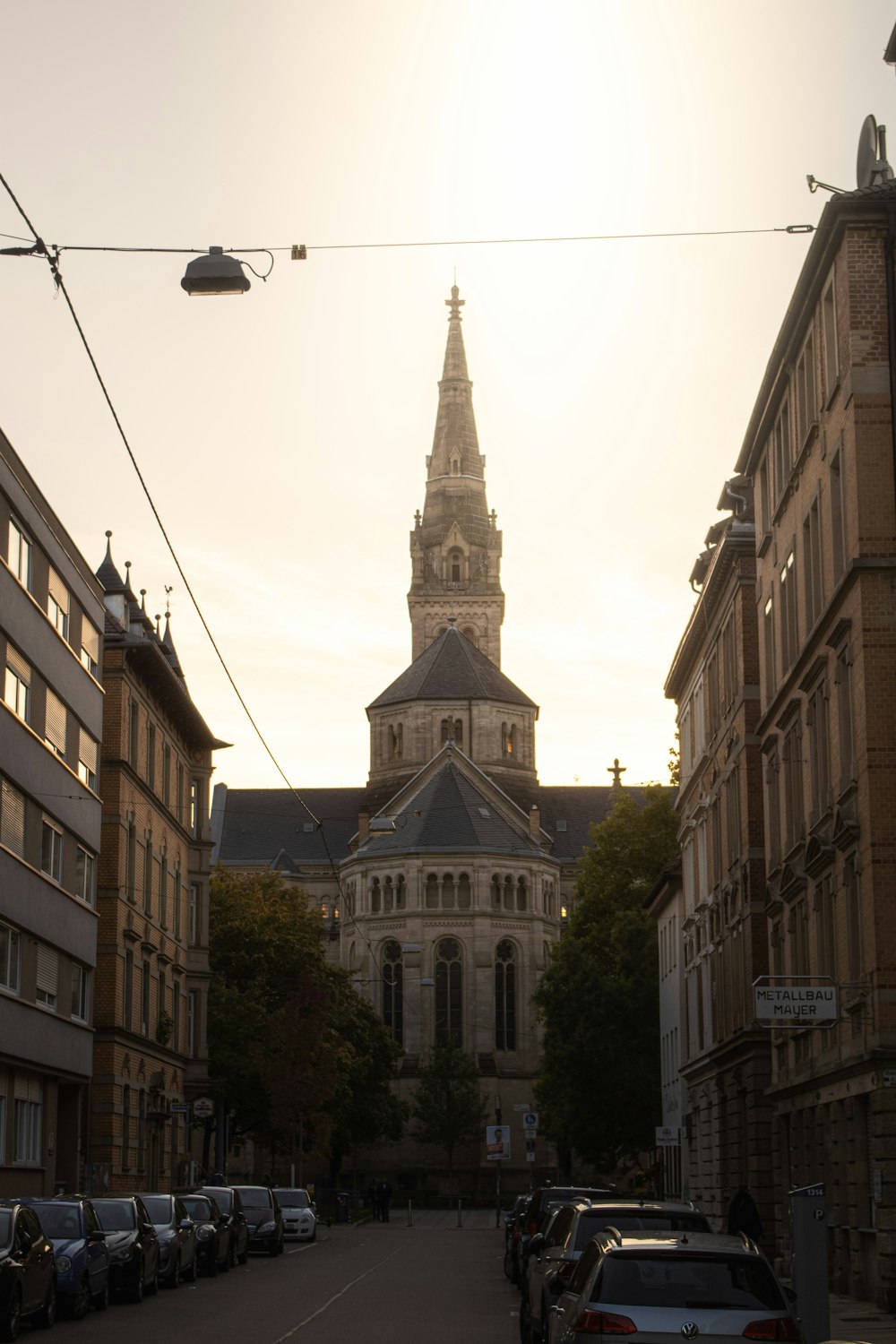 eine Stadtstraße mit einem Kirchturm im Hintergrund