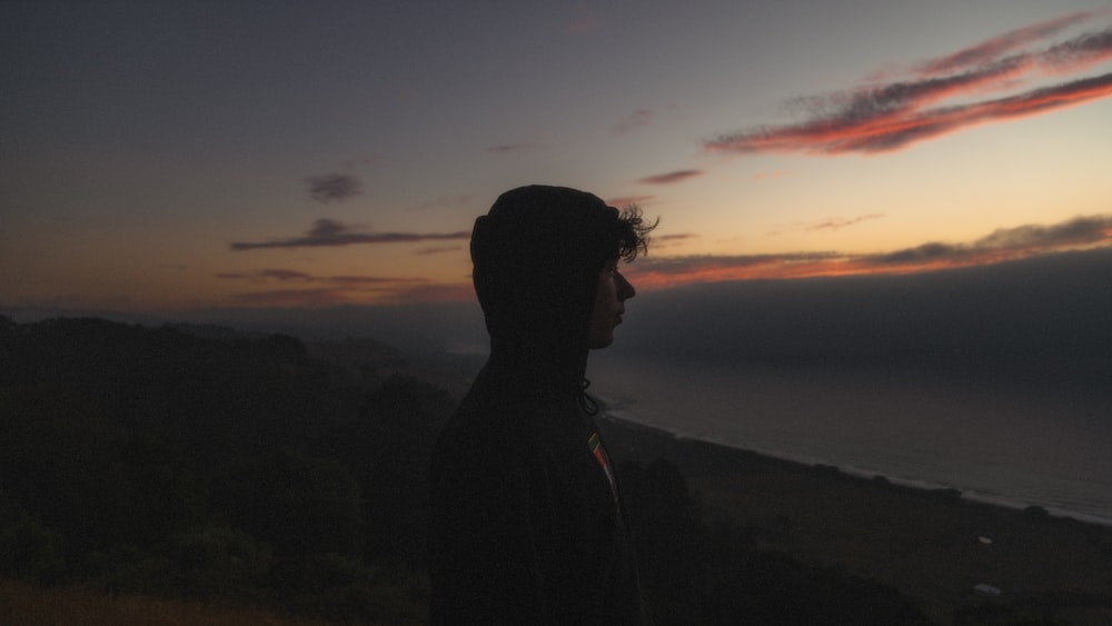 a man standing on top of a lush green hillside