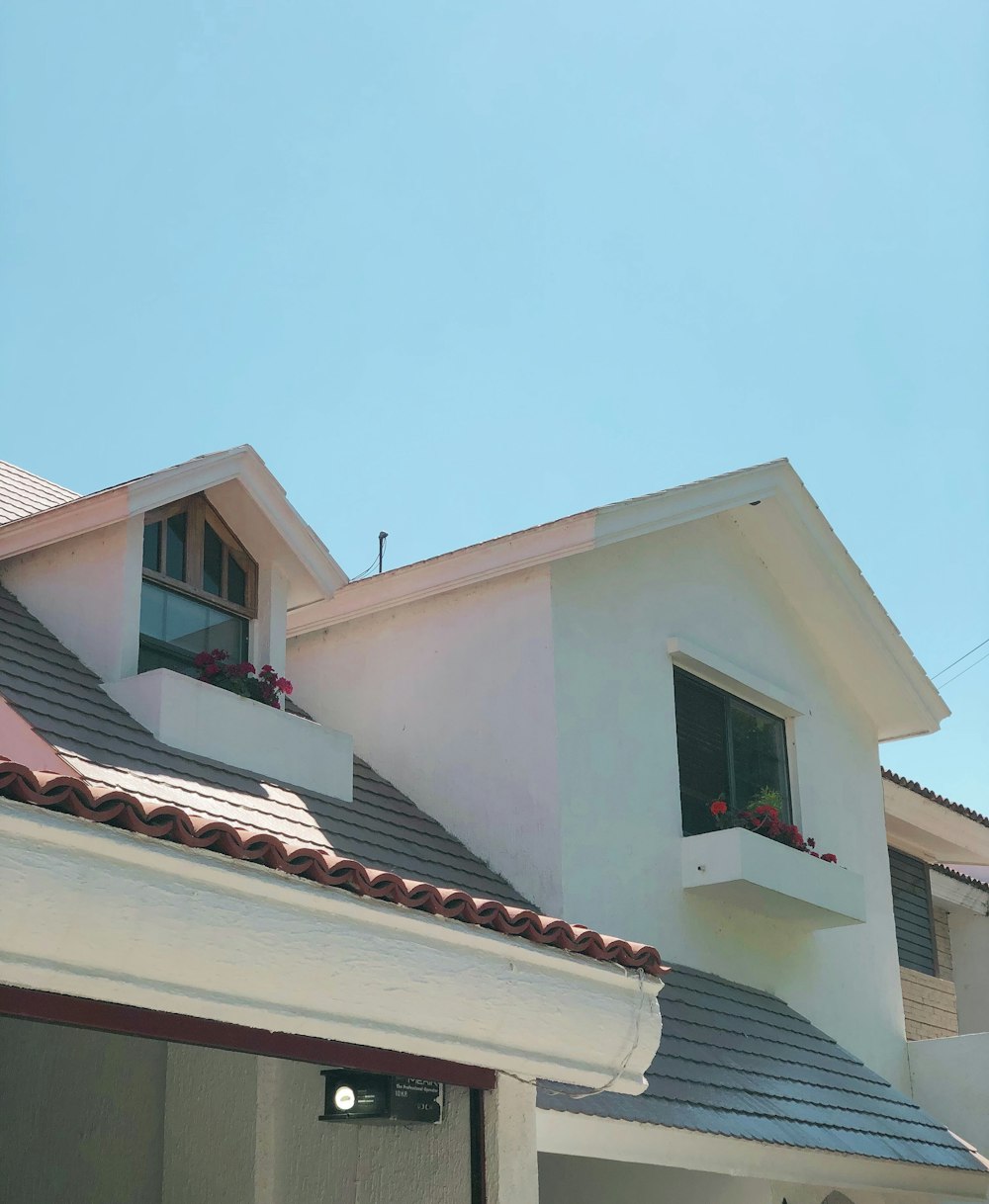 a white house with a red roof and two windows