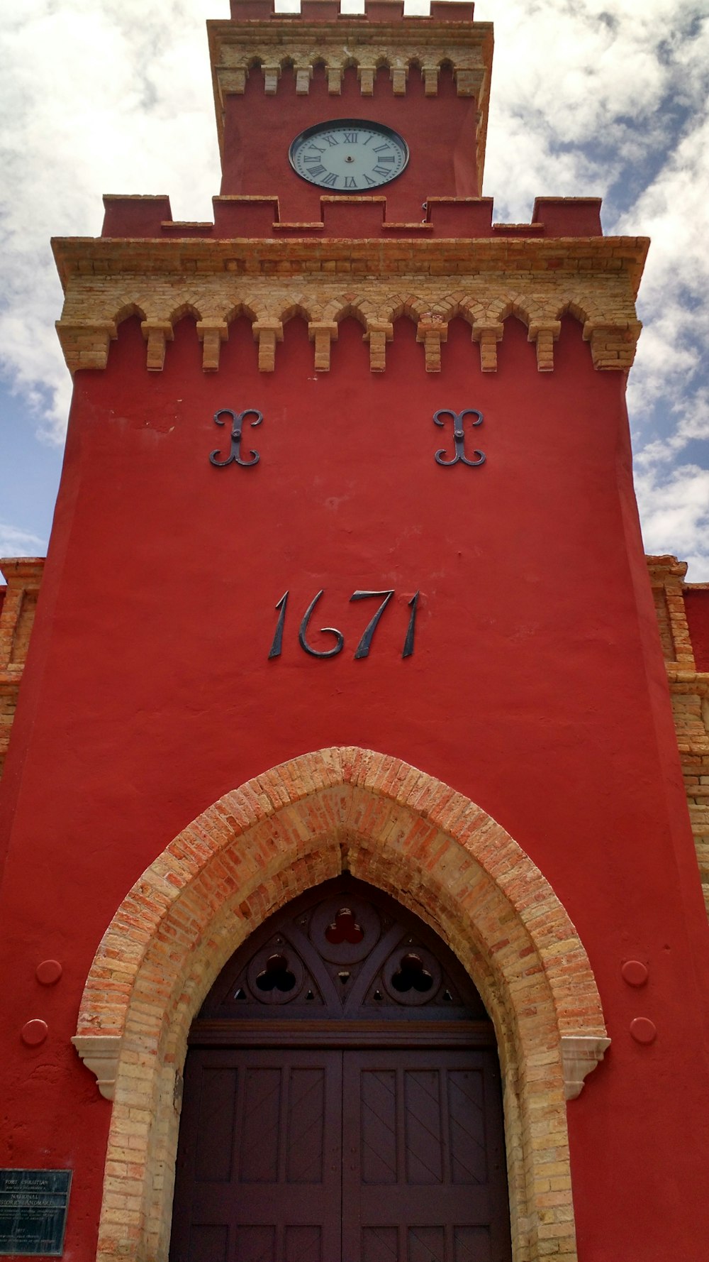 a tall red building with a clock on it's side