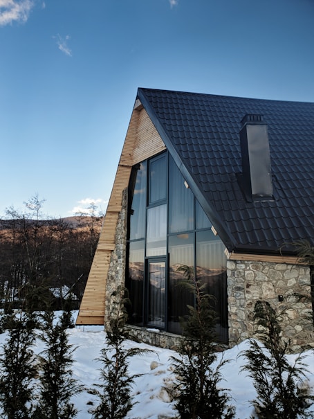 a stone house with a black roof and windows