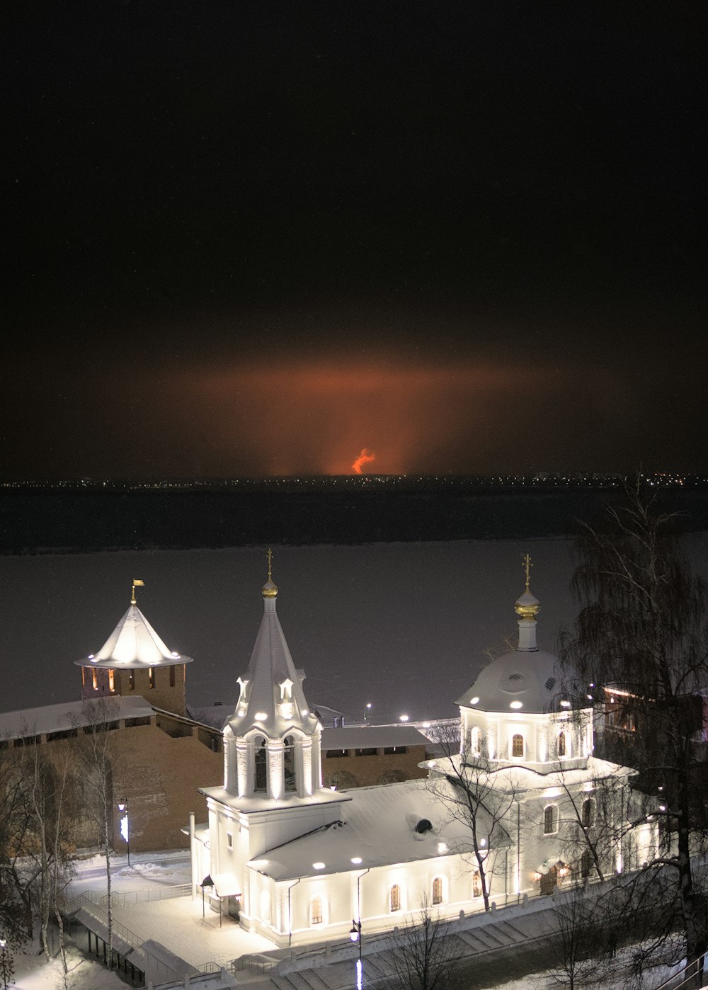 a church lit up at night in the snow