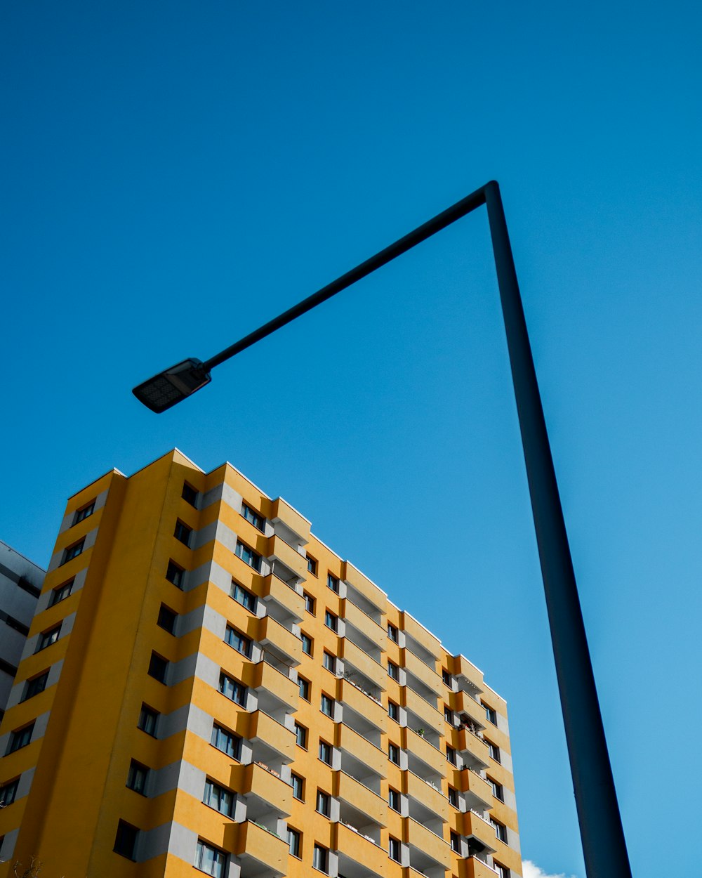 a tall yellow building sitting next to a street light