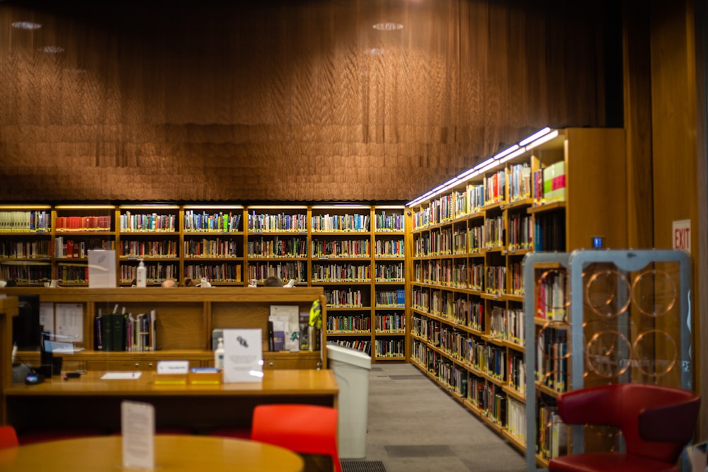 a library filled with lots of books and red chairs