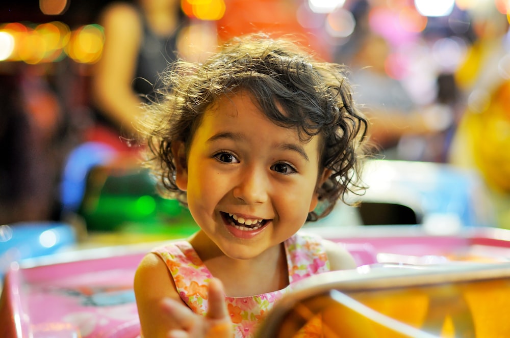 a little girl sitting in a toy car