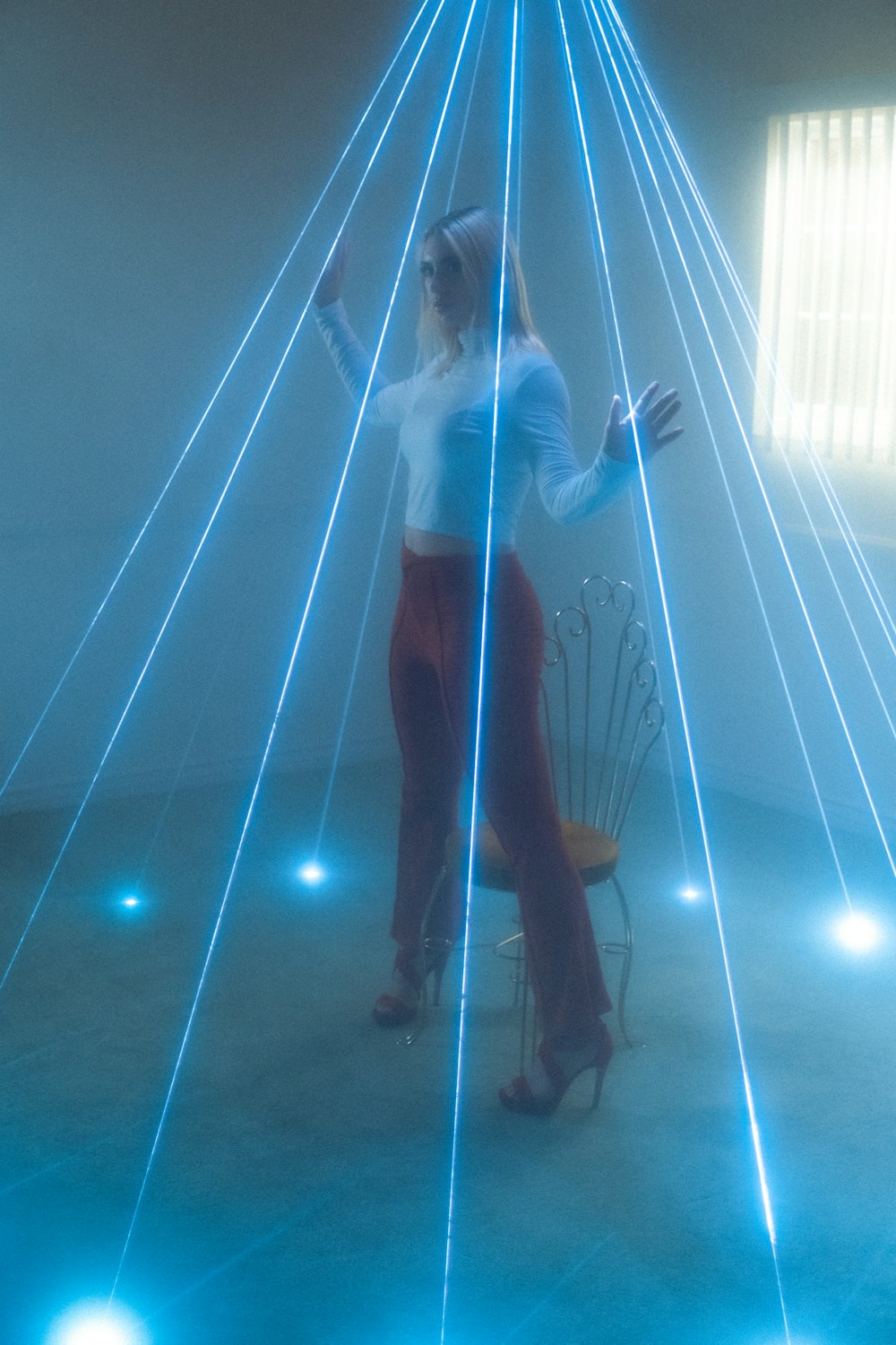 a woman standing in front of a blue light