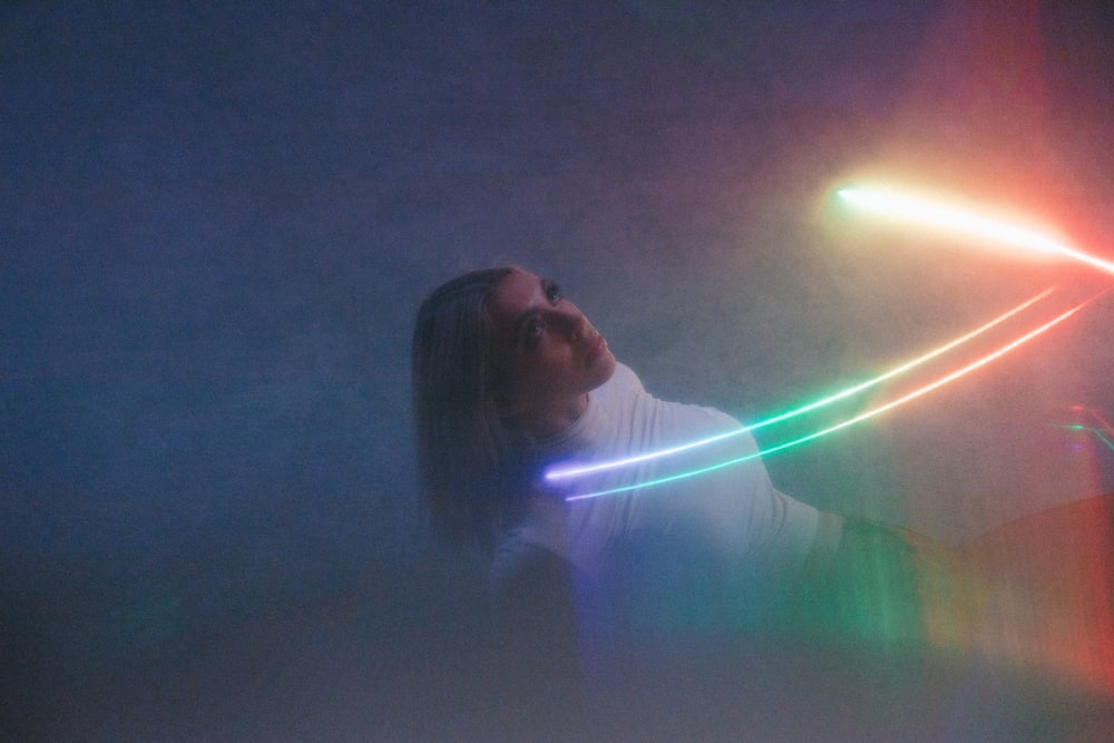 a woman holding a neon light wand in her hand