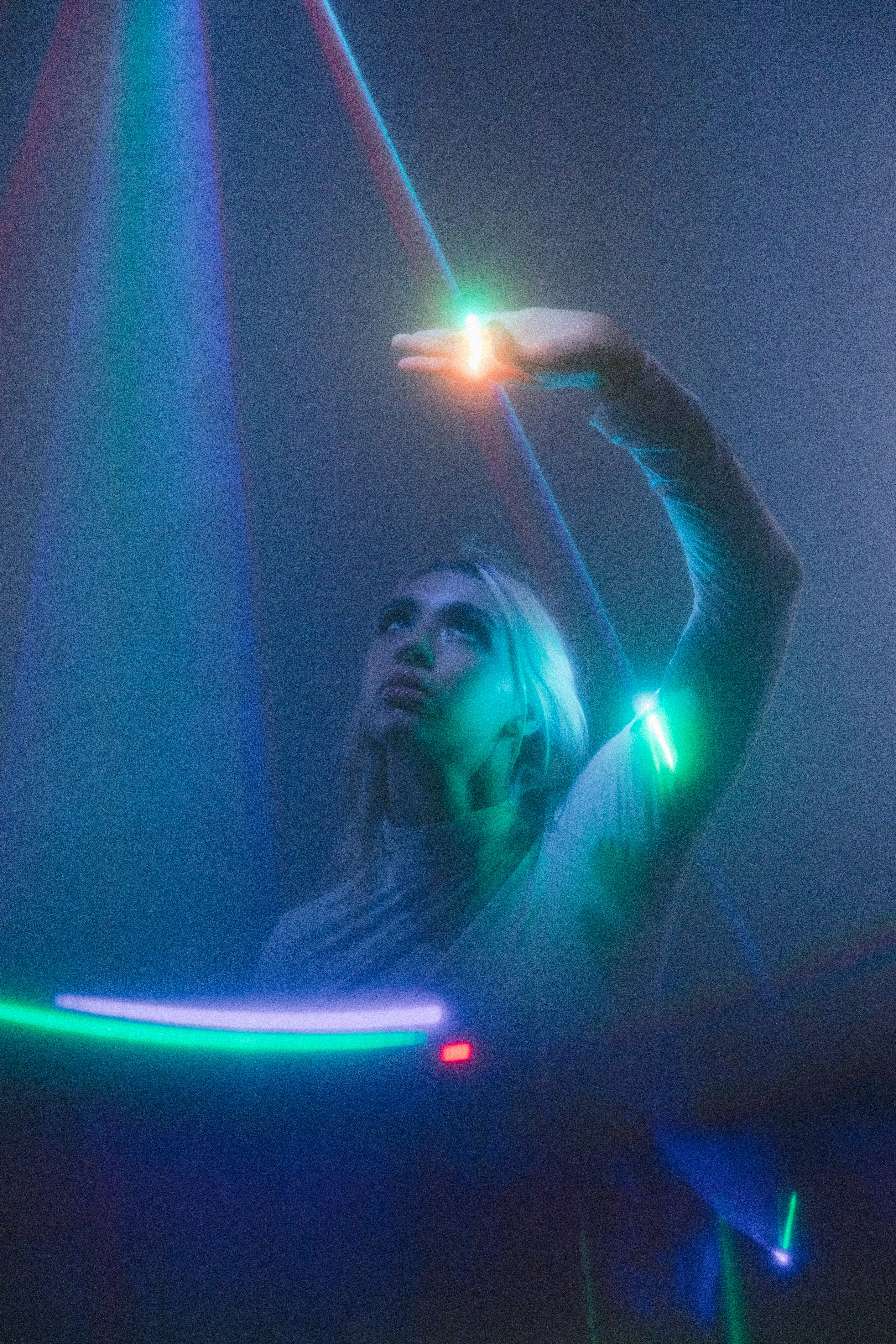 a woman standing in front of a colorful light