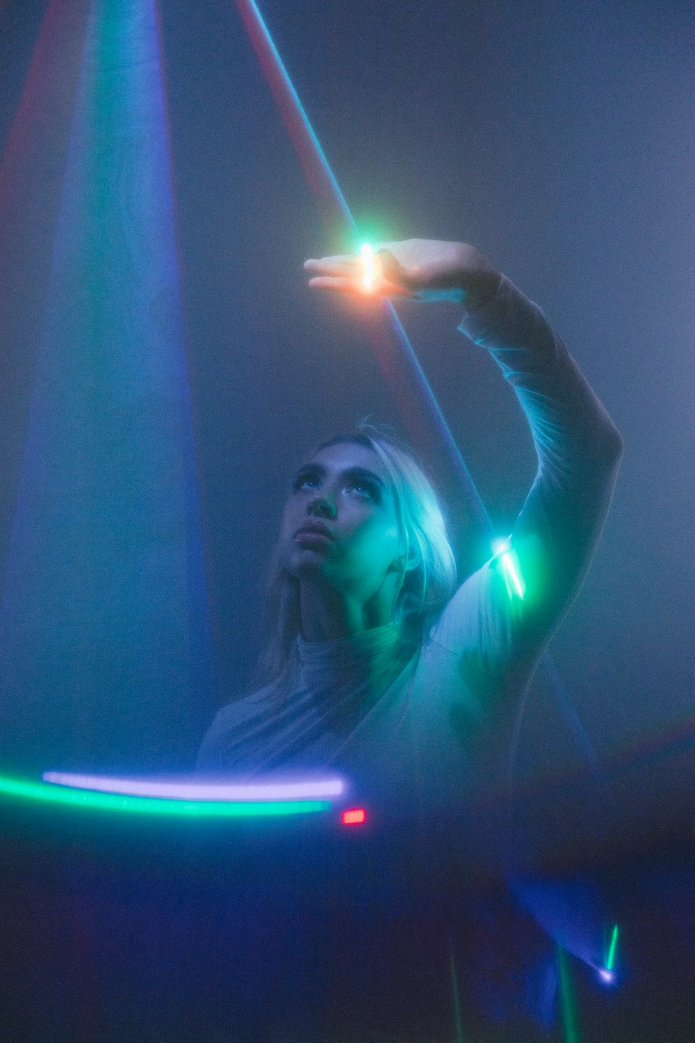 a woman standing in front of a colorful light