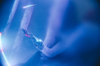 An outstretched hand with ethereal, glowing effects surrounded by soft, blue lighting. The image gives a sense of mystery and otherworldliness, with beams of light and subtle shadows adding depth.