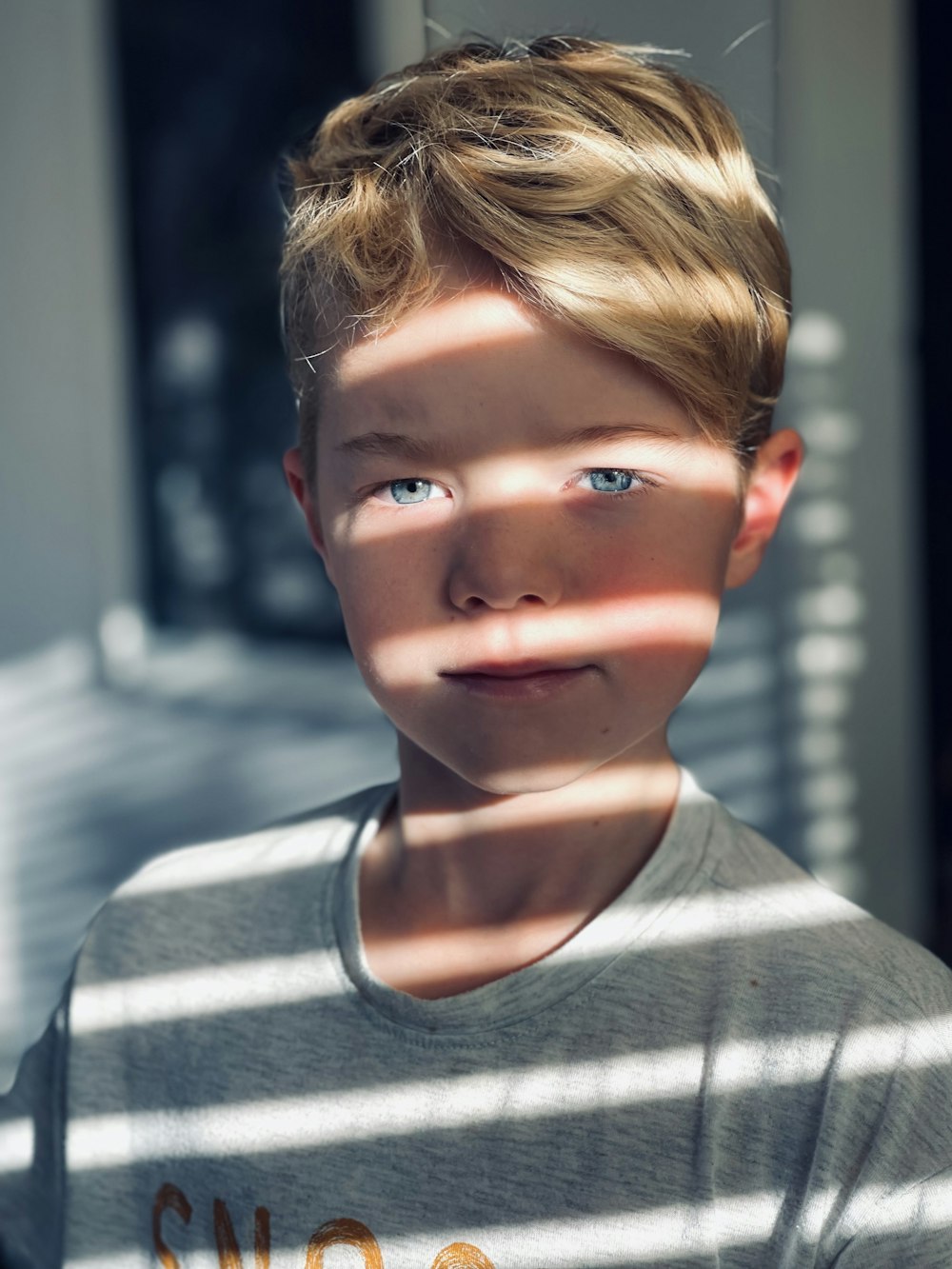 a young boy standing in front of a window