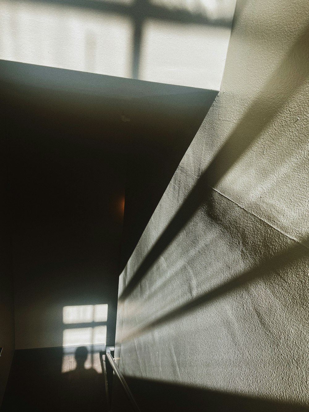 the shadow of a person walking up a flight of stairs