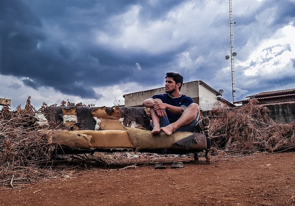 a man sitting on top of a wooden bench