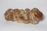 A loaf of braided bread with a golden-brown crust and a dusting of flour on its surface, placed on a plain white background.