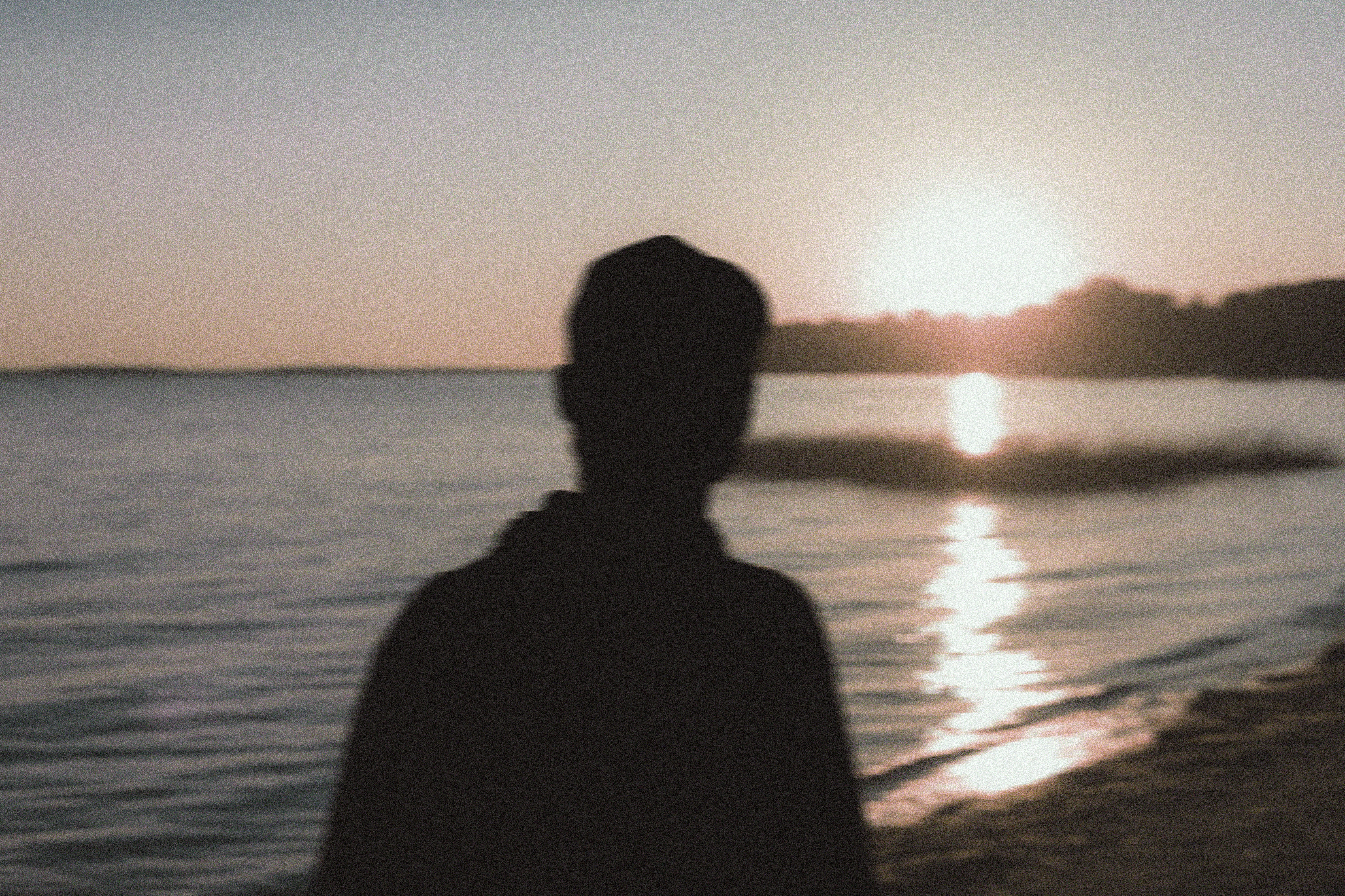 a person standing on a beach looking at the water