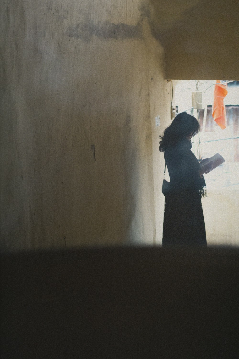 a woman standing in a doorway with a book in her hand
