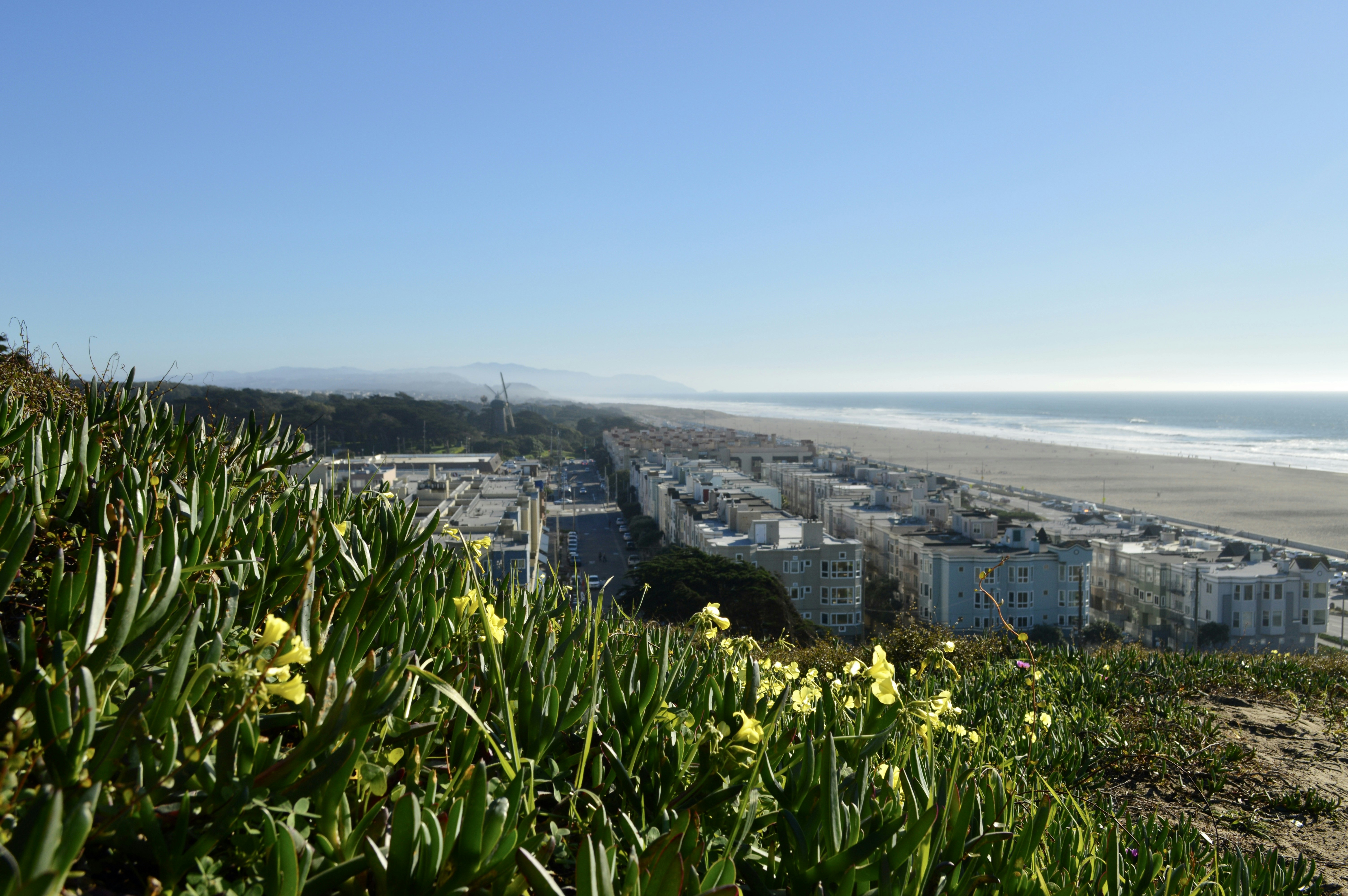 a view of a beach and a city from a hill
