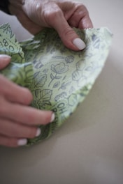 Close-up of hands holding soft organic cotton fabric outdoors.
