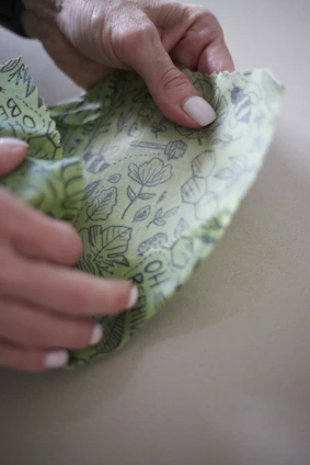 Hands holding a sewing pattern and fabric ready to cut