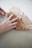 Close-up of hands holding a sheet of parchment paper with a printed logo on a wooden table.