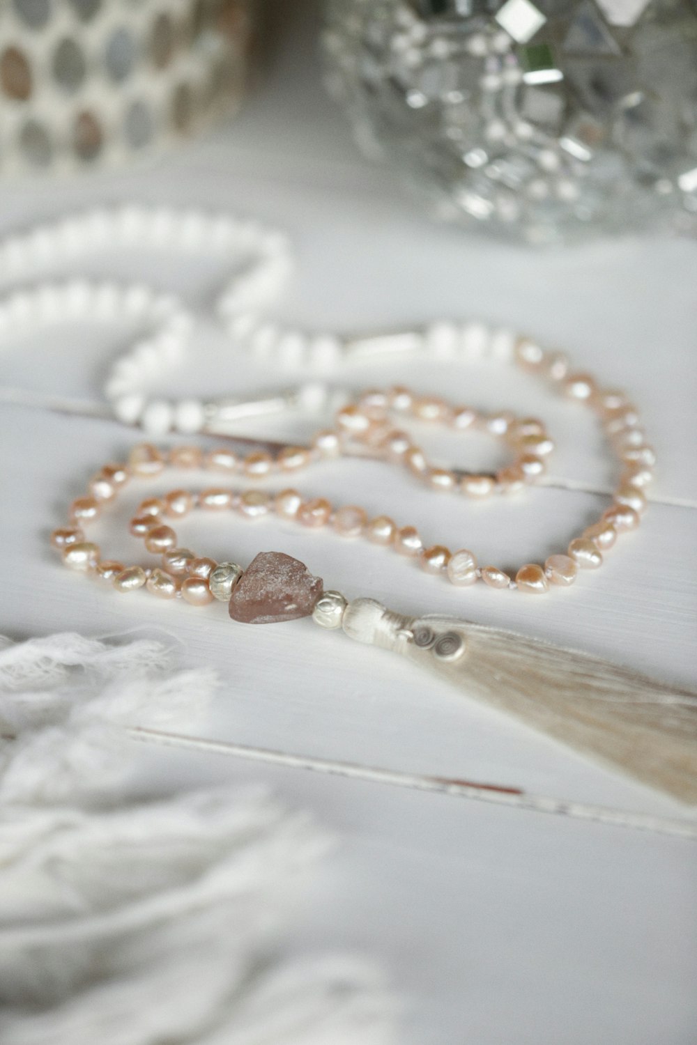 a beaded necklace with a tassel on a table