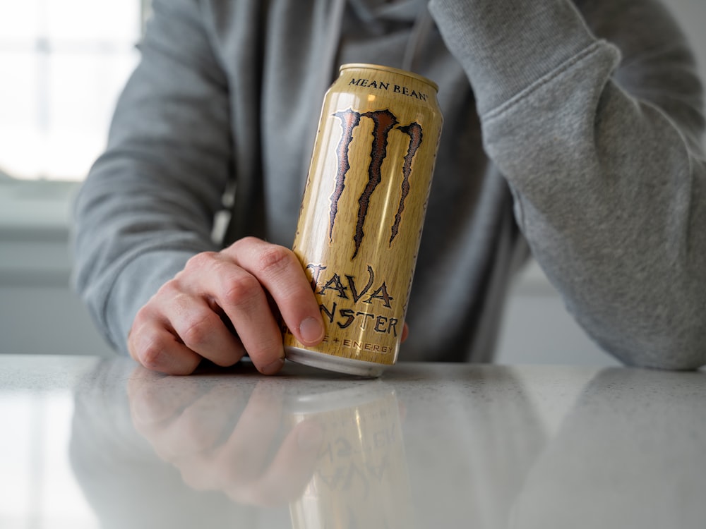 Un hombre sosteniendo una lata de bebida energética monstruosa