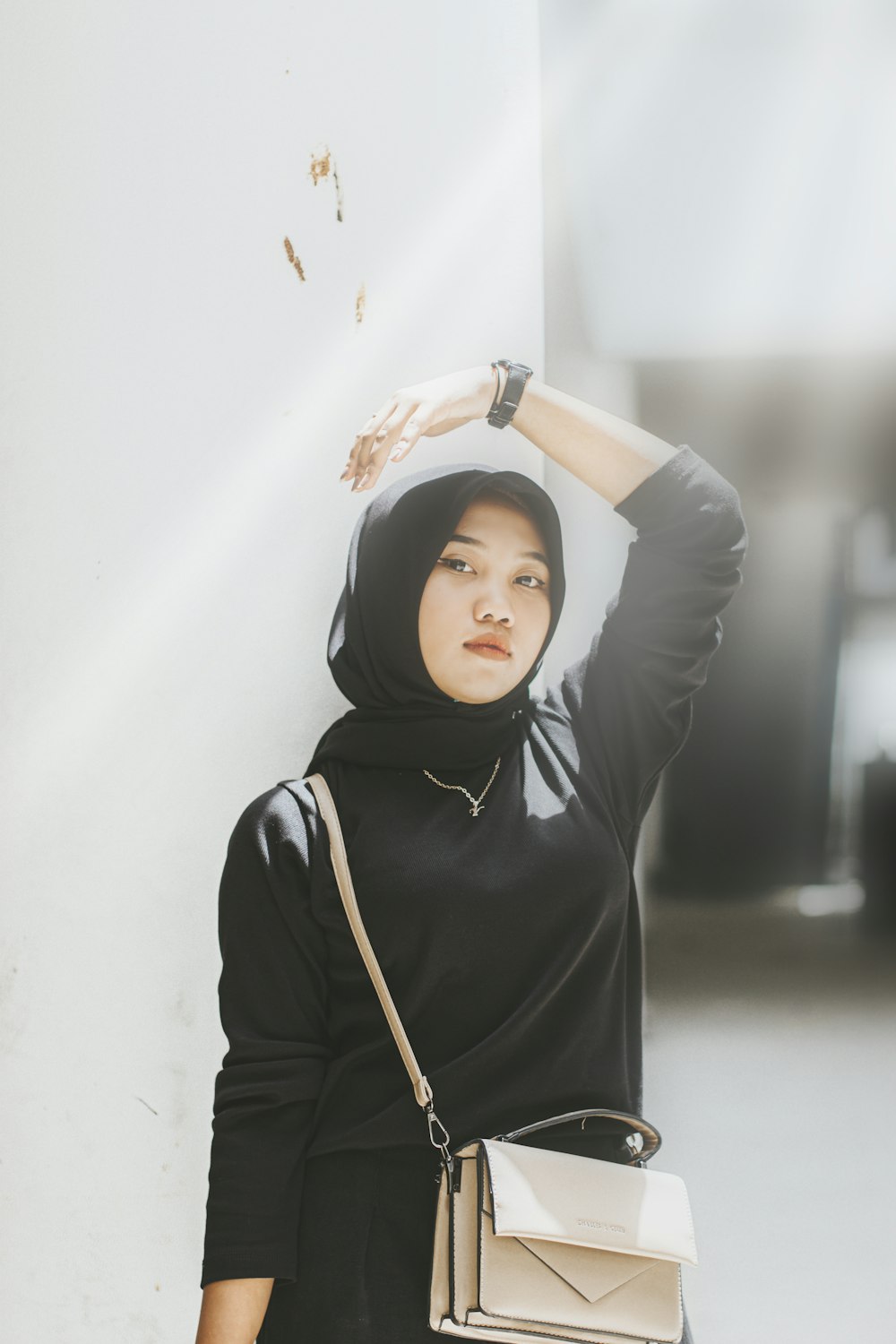 a woman in a hijab is holding a purse