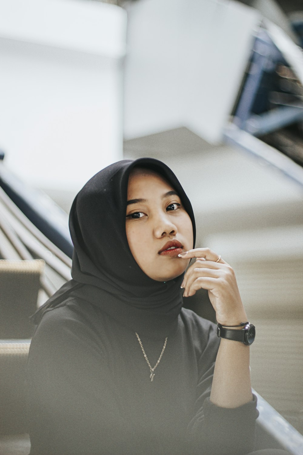 a woman in a hijab sitting on a set of stairs