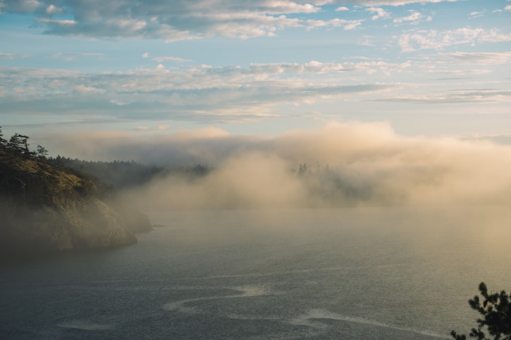 a large body of water surrounded by fog