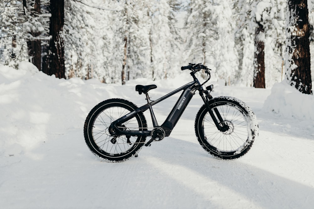 a bicycle parked in the snow in the woods