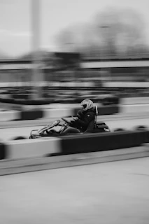 a black and white photo of a person in a go kart