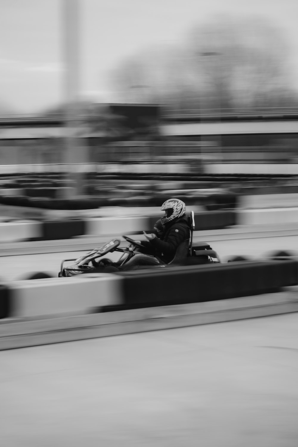 a black and white photo of a person in a go kart