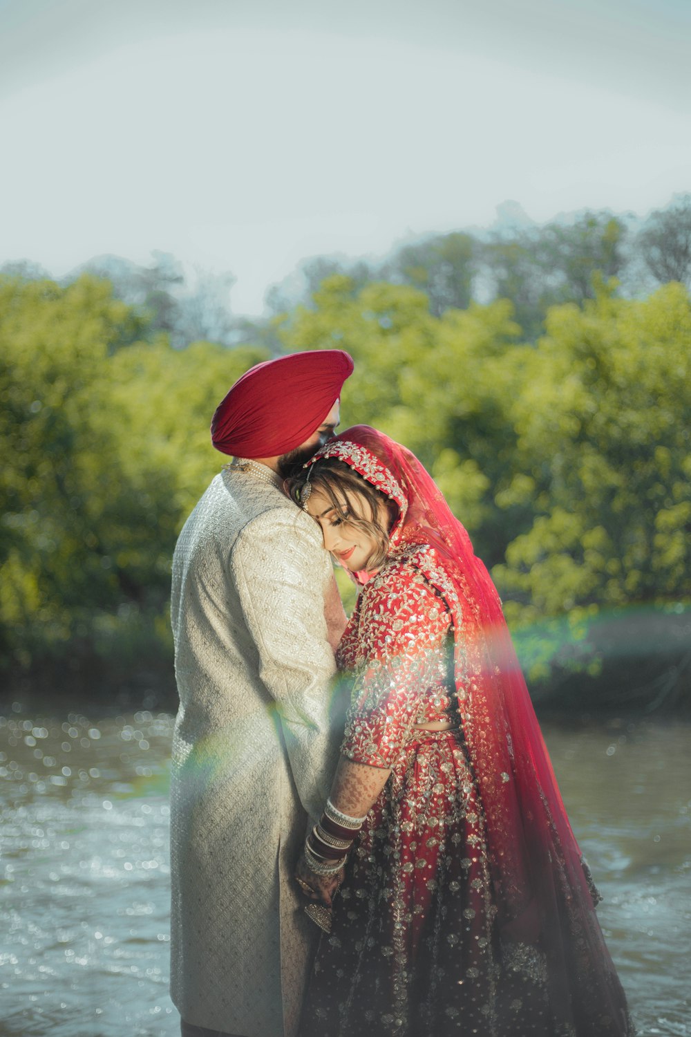 a man and woman standing next to each other near a river