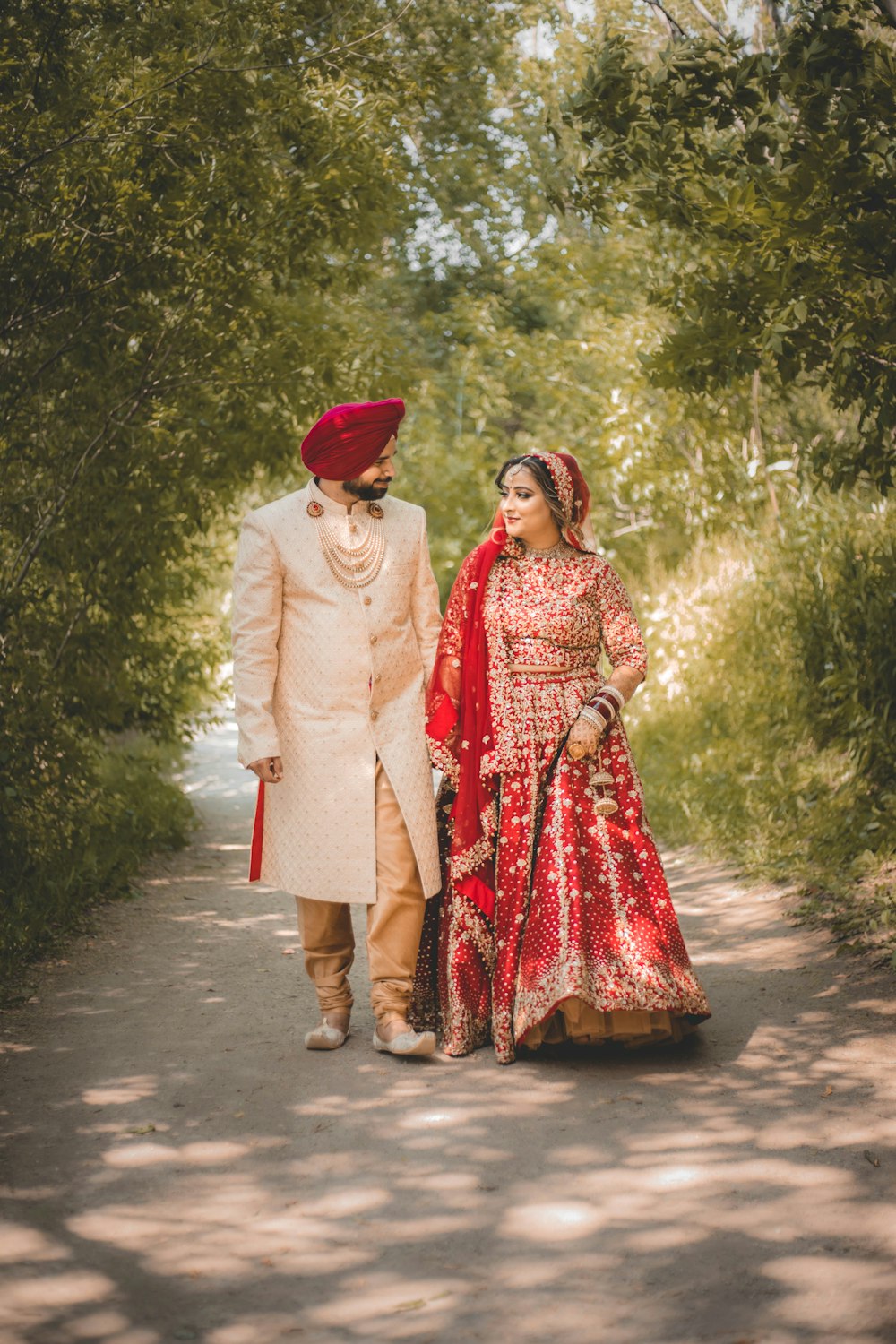 a bride and groom walking down a path