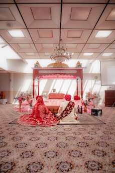 a man and woman sitting on a bed in a room
