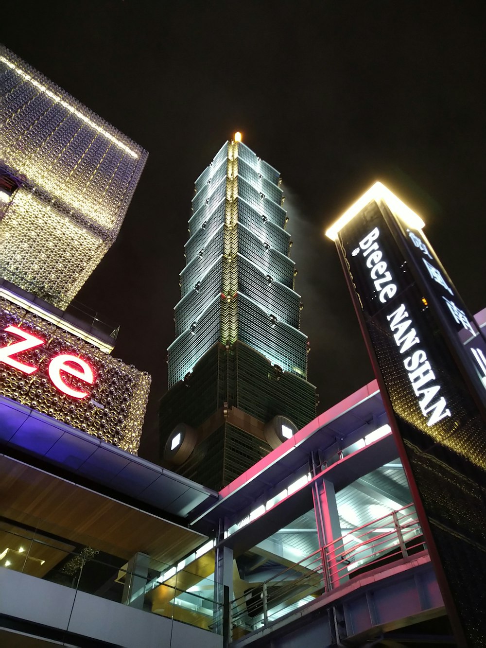 a tall building with a lit up sign in front of it