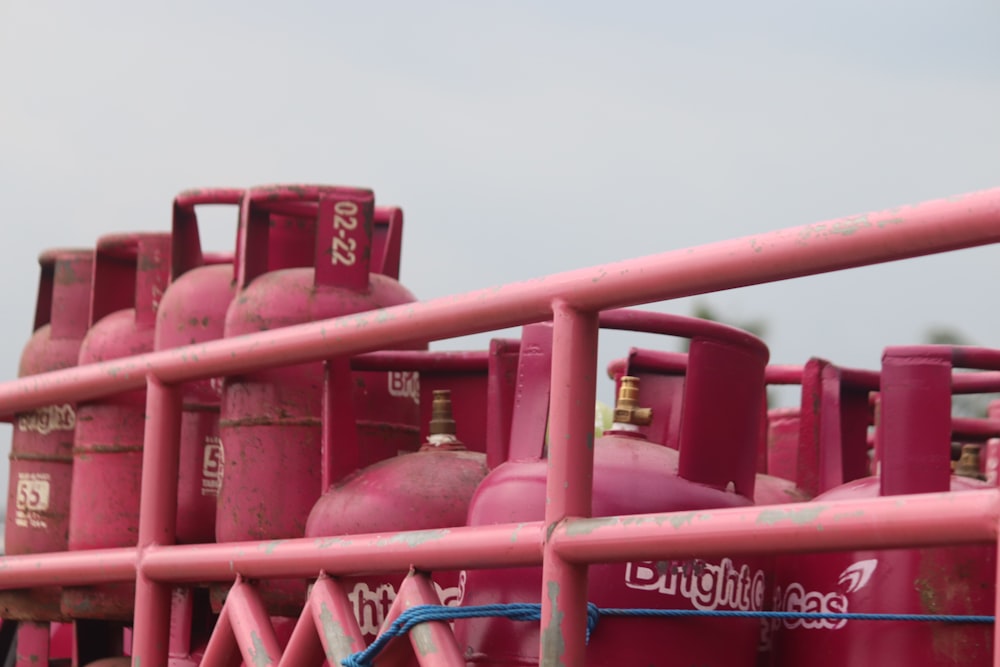 a group of pink gas tanks sitting next to each other