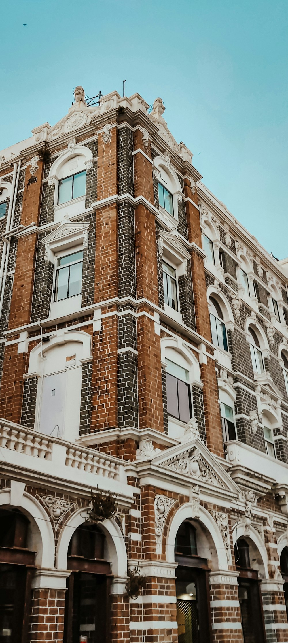 a tall brick building with a clock on the top of it