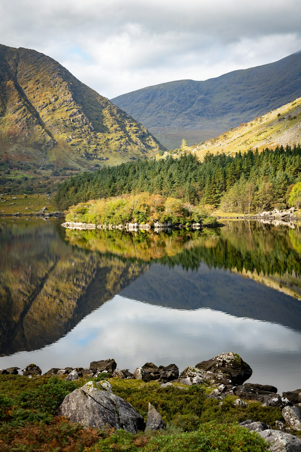 a lake surrounded by mountains in the middle of a forest