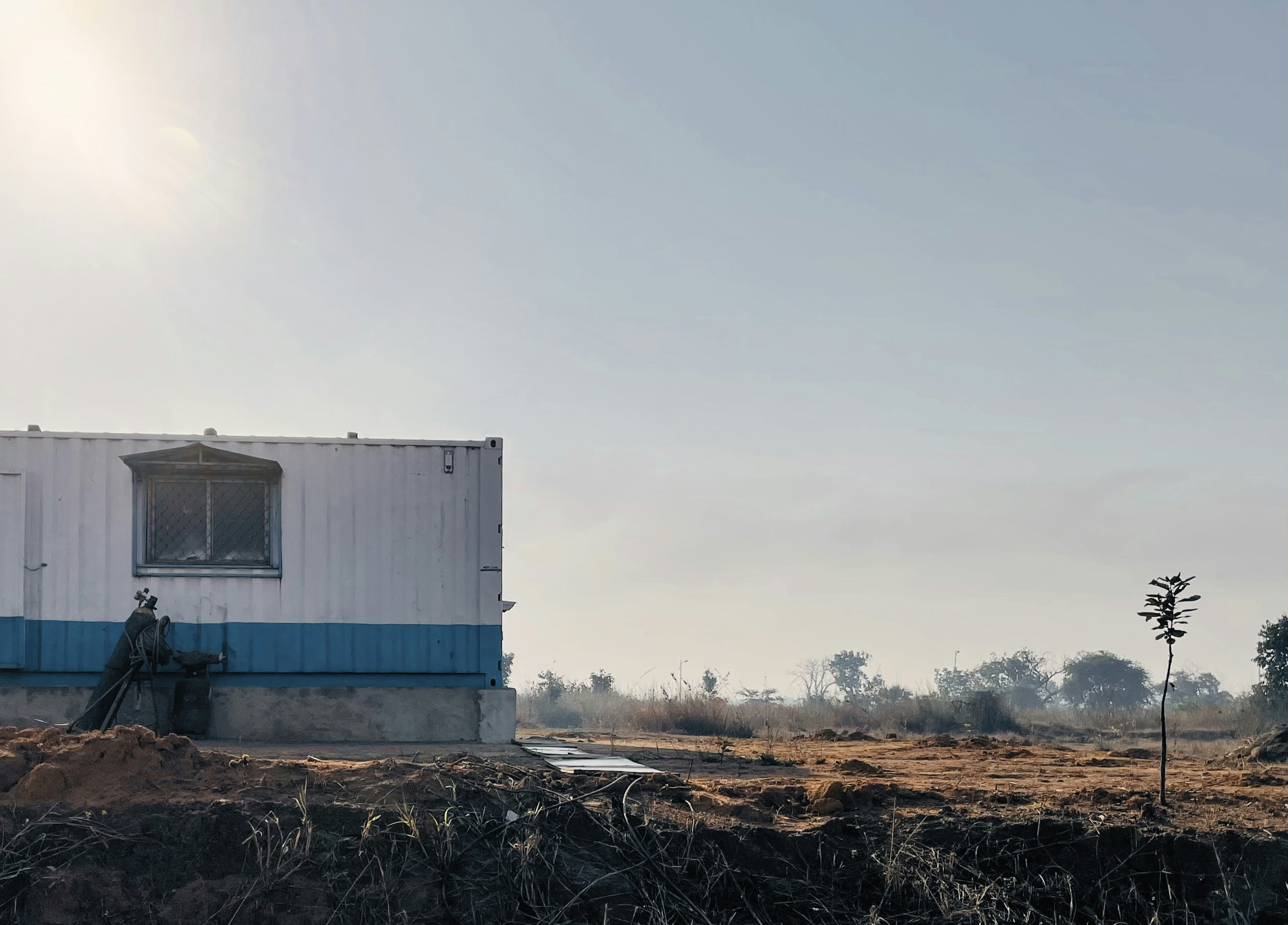 a small white building sitting on top of a dirt field