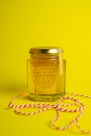 a jar of honey sitting on top of a yellow table