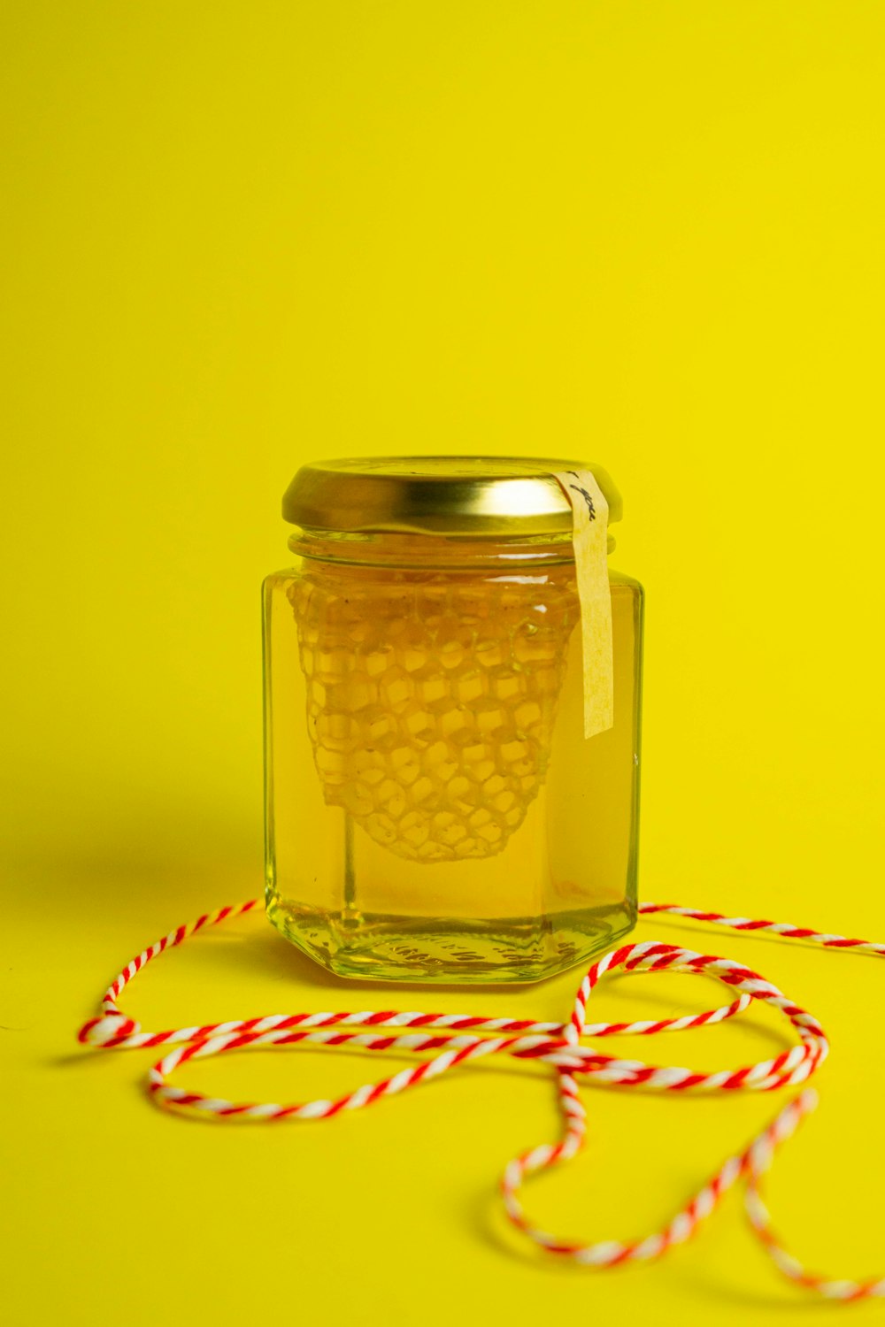 a jar of honey sitting on top of a yellow table