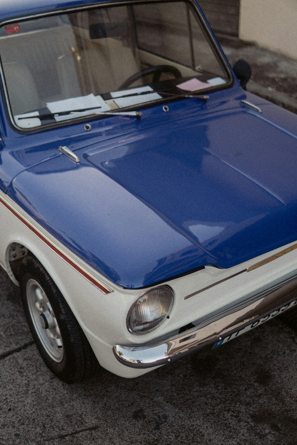 a blue and white car parked on the side of the road