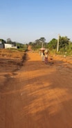Local community members smiling beside the improved highway, showing connection and progress.